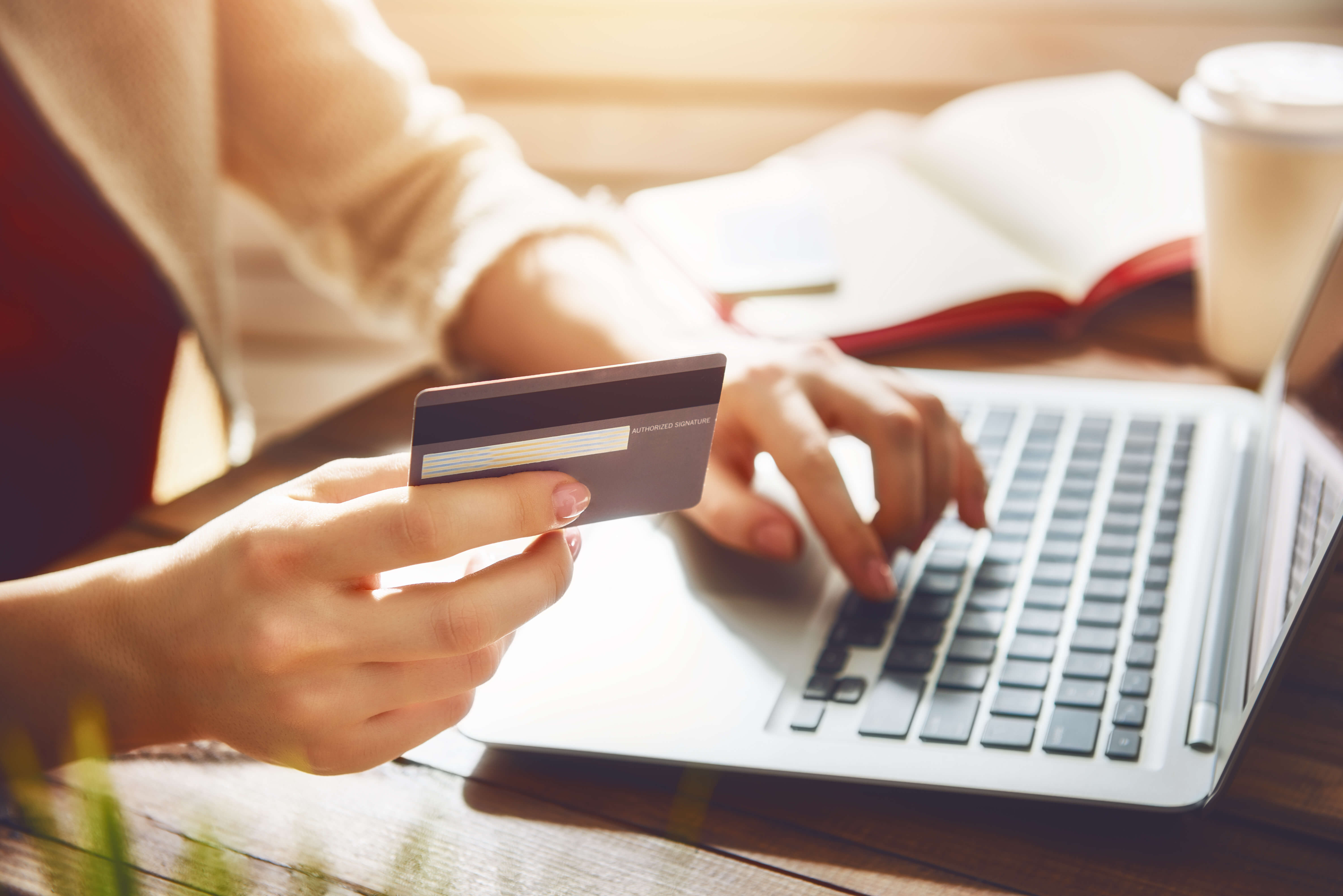 Woman is holding credit card and using laptop computer. Online shopping concept. Close up.